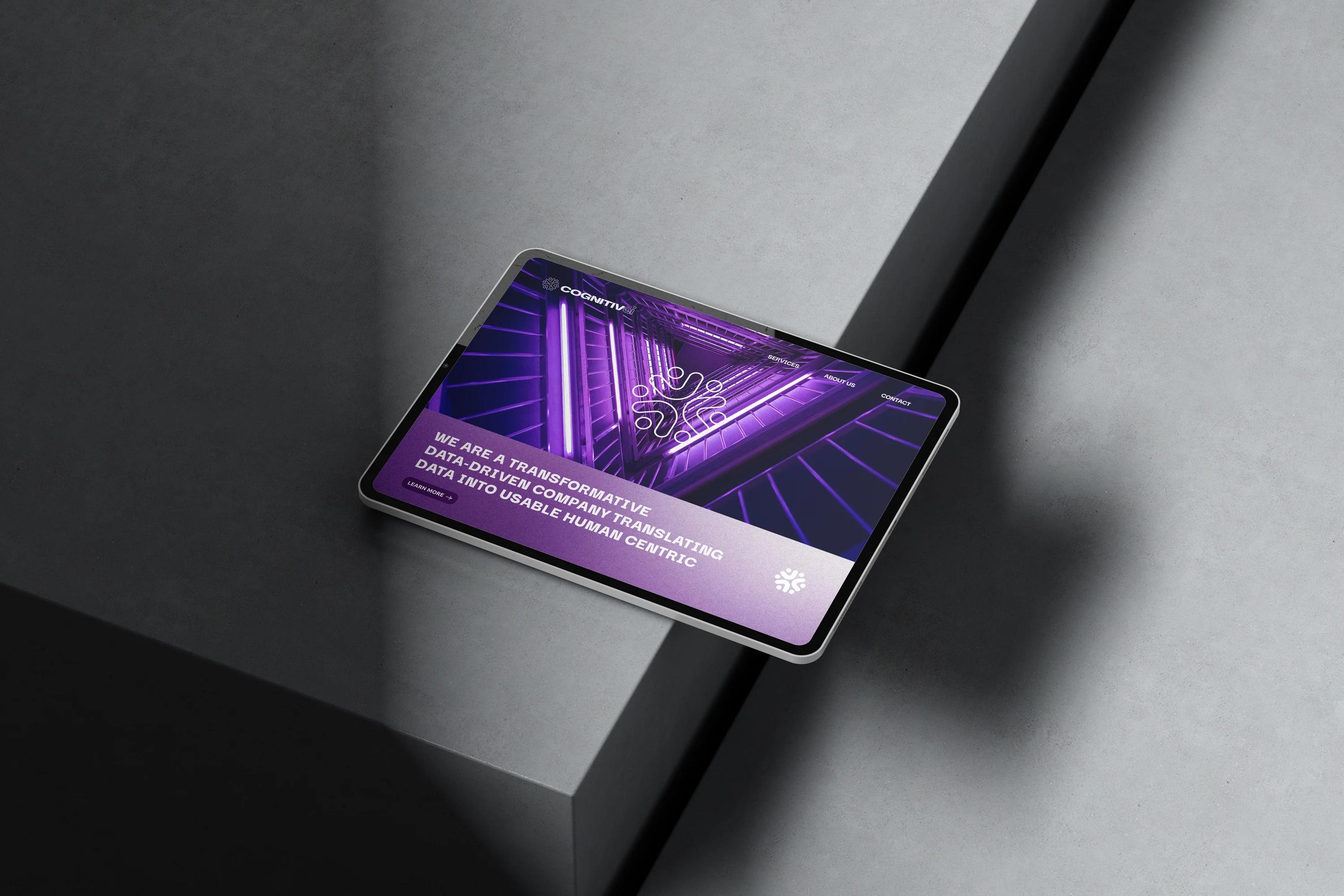 A tablet on a concrete block showing the website homepage: a violet corridor of light behind the positioning statement.